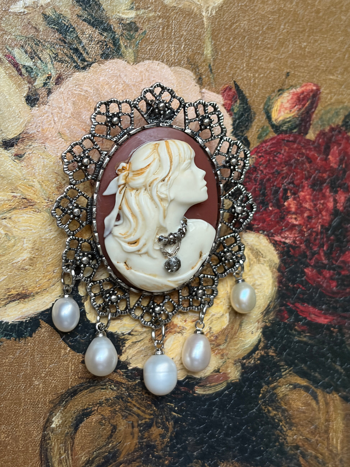 Close-up of Victorian cameo brooch showing cascading pearl fringe on ornate filigree frame